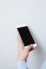 Closeup shot of a woman hold on mobile phone. Girl's hand holding a modern smartphone. Blank screen to put it on your own webpage or message.