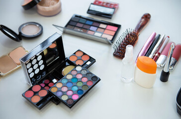 Female decorative cosmetic with lipstick and eyeshadow palette on the table