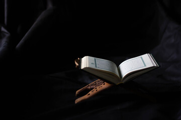 The Holy Quran in Mosque - Open to Read - Study the black background practices of Muslims around the world placed on wooden boards in low-light mosques.