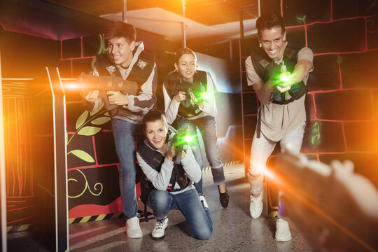 Group of young people playing laser tag game with laser guns. High quality photo