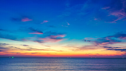 Beautiful sunset over the clam sea with cloud and sky background. Sunset over tropical beach. Nature summer  concept. Peak sunset over sea with yellow light reflect in cloud.