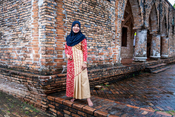 Fototapeta premium Happy attractive muslim woman travel in Pattani province, Thailand. Posing in courtyard of Mosque. Religion and tourist concept.
