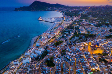 Scenic aerial view at twilight of Altea cityscape on Mediterranean coast overlooking illuminated...