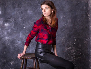 Fototapeta na wymiar Studio portrait of young beautiful woman in a leather skirt