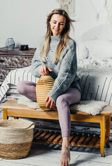 beautiful young woman with long hair model on a bed in a bedroom interior in light colors.