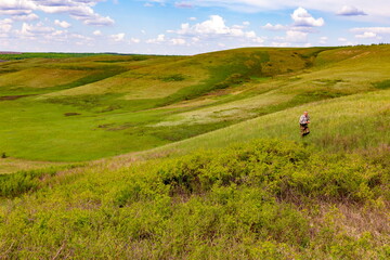 Man Tourist travels through the hilly forest-steppe in the Samara region. Spring sunny day.