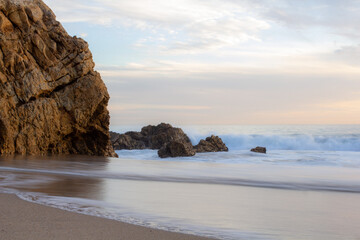 Fototapeta na wymiar Smooth waves on sandy beach in California
