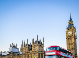 Big Ben and blurry red bus in motion in London