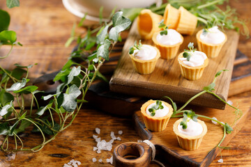 Canapes with light cream filling. Still life with microgreens. The concept of an appetizing snack.