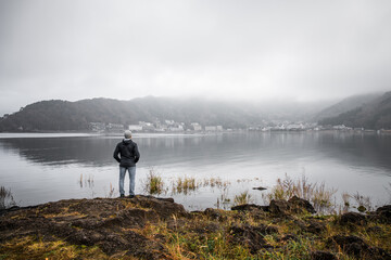 Man staring at the foggy lake