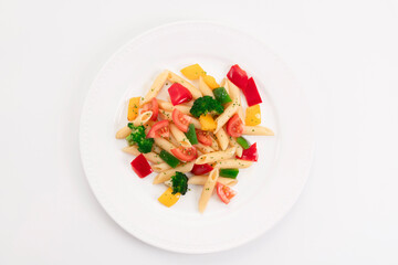 Top view of a delicious looking plate with freshly cooked pasta and vegetables on a light background. Healthy food and pasta concept.