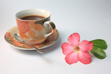 Fototapeta na wymiar Red Adenium flower and a cup of coffee