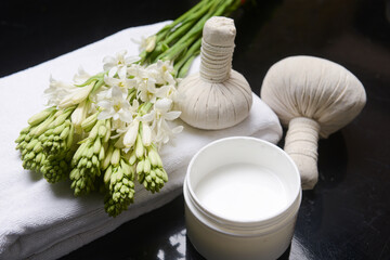 spa concept with bunch of tuberose flowers ,buds, herbal, ball, on towel and cream in bowl