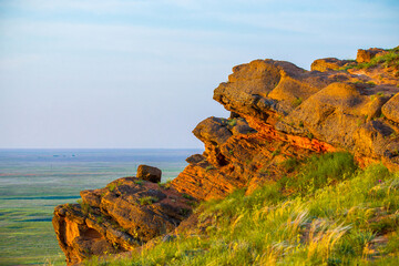 Big Bogdo mountain. Red sandstone outcrops on the slopes sacred mountain in Caspian steppe Bogdo -...