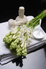 Foto op Canvas spa concept with bunch of tuberose flowers ,buds on towel, cream in bowl and herbal, ball,   © Mee Ting