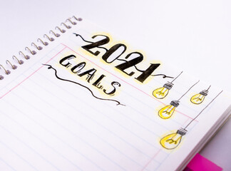 Decorated notebook for writing New Year's resolutions on a white table.