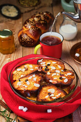 Freshly baked bread pudding with raisins, almond flakes and cardamom in a baking dish on the table....