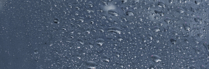 Water rain drops blue Vintage on glass wall on car rain drops on clear window or rain droplets on...
