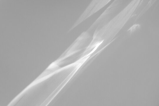 Blurred water texture overlay effect for photo and mockups. Organic drop diagonal shadow and light caustic effect on a white wall. Shadows for natural light effects
