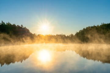 Fototapeta na wymiar Sunrsise at the lake with morning fog