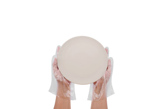 Women Hand Wearing Plastic Gloves Holding Empty Ceramic White Plate Isolated On White Background. Top View. Way To Protect Hands Directly Touching The Food Container.