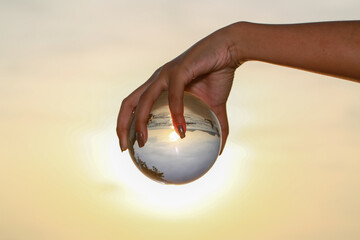 Fototapeta na wymiar .lady catch the crystal ball on her hand beside Patong beach during sunset