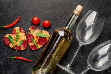 Dinner for two. Two heart-shaped pepperoni pizzas and a bottle of white wine, glasses, Valentine's Day gift.