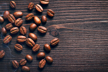 Aromatic coffee Beans on a wooden table with smoke