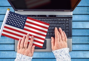 woman hands and flag of United States on computer, laptop keyboard
