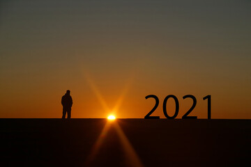 Silhouette of 2021 year letters on the rooftop with sunset light, Concept new success , goal , target start 2021  