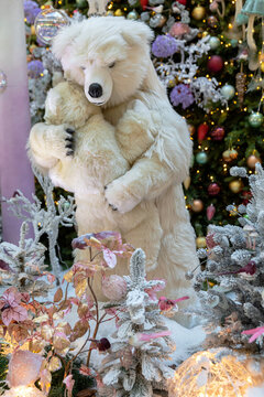 A polar she-bear holding a bear-cub in her arms by the Christmas tree. Dana shopping center - Minsk city, Belarus December 8, 2020.