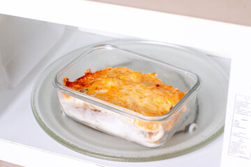Potato casserole with meat in a container in the microwave. Ready meals