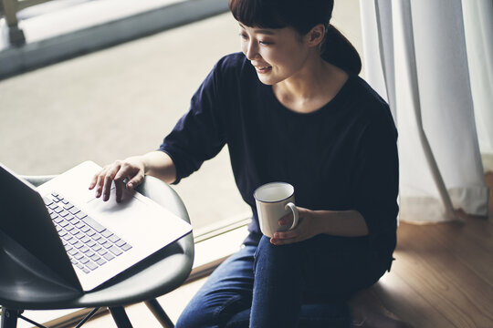 パソコンを見ながらくつろぐ女性