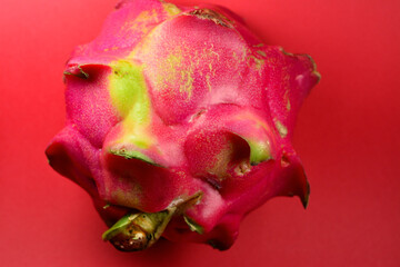 Fresh dragon fruit that is still intact on a red background