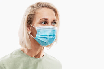 Young blond woman in medical mask. Coronavirus pandemic. Isolated on white background. Space for text.