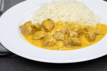 morceaux de poulet sauce curry et riz dans une assiette