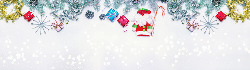 Holiday banner green Christmas tree with red and blue gifts on a light wooden background. Background happy New year greeting card Christmas Winter theme copy space for text. Snowfall.