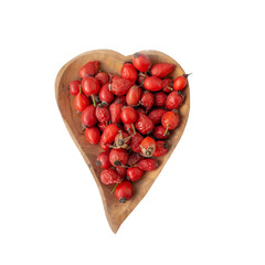 Rosehip berries in a wooden bowl in a heart background isolated on a white background. Berries for making vitamin tea or drink