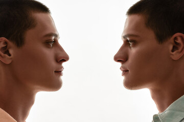 Family relationships concept. Silhouetted portrait of two young caucasian twin brothers looking at...