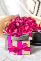 Gift boxes and bouquet of flowers on the bed. Concept of Valentine's day, March 8, birthday gift and other holidays.