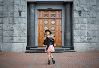 Fototapeta na wymiar Girl in black hat posing on the street in the old city, copy space
