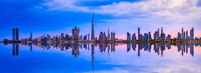 Sunset skyline panorama of Dubai with reflection, UAE