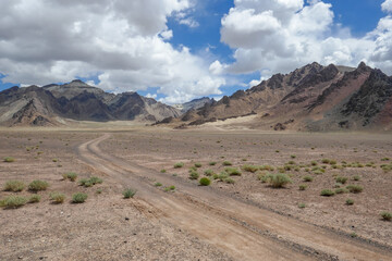 Scenic mountain landscape view of high-altitude desert with dirt tracks near Pamir Highway between Murghab and Ak Baital, Gorno-Badakshan, Tajikistan