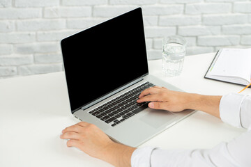 Obraz na płótnie Canvas Man in white shirt working on laptop