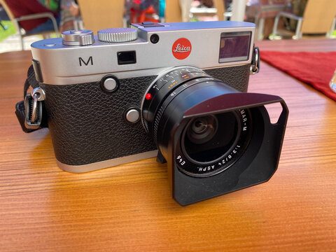 Sankt Ulrich, Italy - August 2020, Close-up Of Famous Leica M Camera With Elmar-M Lens On Wooden Table. The Leica M (Typ 240) Is A Full-frame Digital Rangefinder Camera Of Leica Camera AG Germany. 