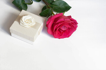 Red rose and white gift box on a white background, copy space