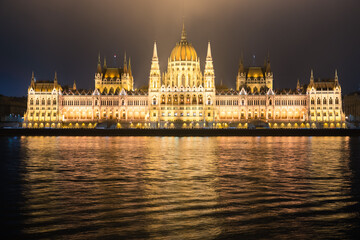 Fototapeta premium Hungarian Parliament viewed at night on the Danube river in Budapest