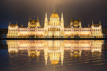 Fototapeta premium Hungarian Parliament with reflection viewed at night on the Danube river in Budapest