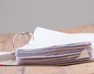 Aktenordner aufgeklappt, auf Holz mit grauen Hintergrund zur Texteingabe.