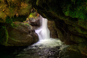 Fototapeta na wymiar waterfall in the forest under rocks